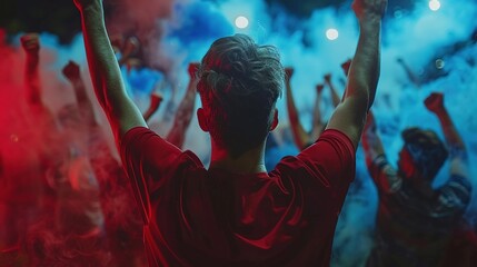 A man is standing in a crowd of people, with his arms raised in the air