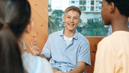 Attractive boy sharing experience during attend in group therapy. Highschool student talking about...