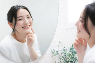Woman looking in the mirror and concerned about the texture of her skin Image of skin care and...
