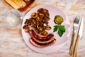 Grilled sausages served with roasted mushrooms with onion and pesto sauce