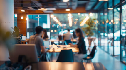 Blurred office interior with business people working in a team, sitting at desks and using computers. Concept of corporate life or work culture.
