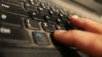POV: person using a laptop. Man using a laptop keyboard. Person using a notebook. Qwerty keyboard,...