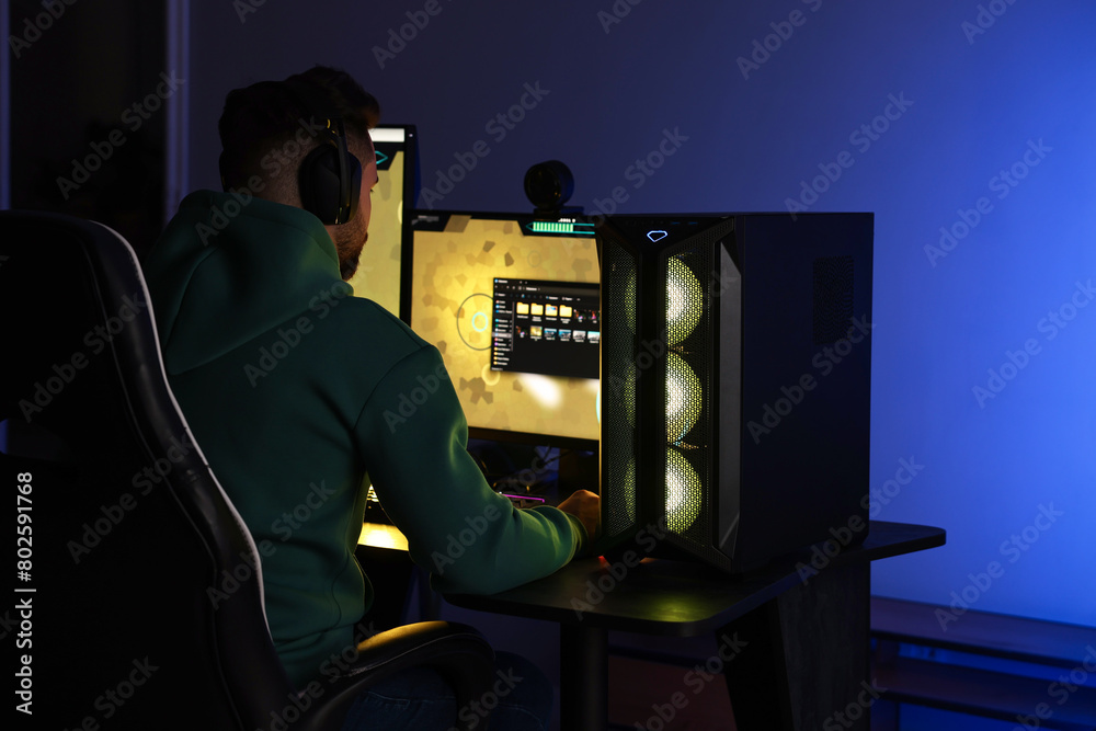 Wall mural man playing video games on computer at table indoors