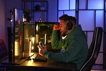 Man playing video games with controller at table indoors