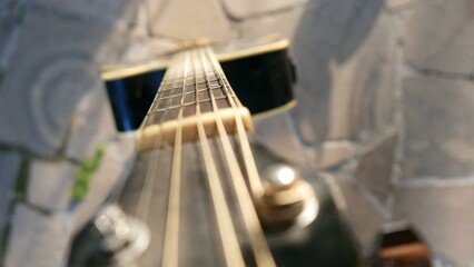 Guitar strings: an acoustic guitar isolated under the sun. Acoustic guitar, close-up shot. A...
