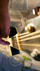 A fretboard, top view. A musician with his guitar. A guitar neck. Man testing a guitar. A guitar in...