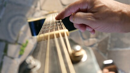 POV: a musician reaching for a guitar. A guitarist next to an acoustic guitar. Playing guitar day.  A guitar fretboard.
