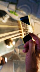 POV: a guitarist picking up a guitar. A top view of an acoustic guitar. A guitar under sunbeams. A...