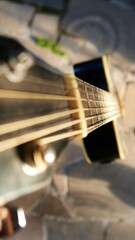 An acoustic guitar isolated in the sun. Acoustic guitar, close-up shot. An old guitar, top angle. A...