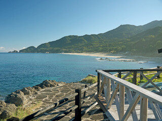 Yakushima coast panorama on sunny day, Inakahama sandy beach turquoise sea water, blue sky, distant...