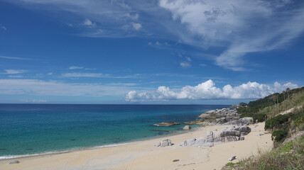 Yakushima coast panorama on sunny day, Inakahama sandy beach turquoise sea water, blue sky, distant Kuchierabujima isalnd