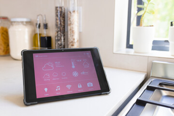 A tablet displaying smart home interface rests on kitchen counter at home