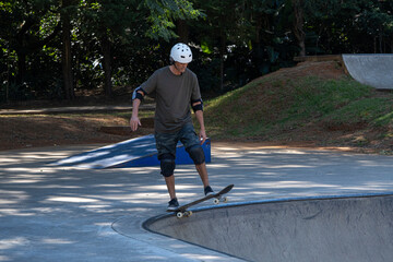 54 year old Brazilian skateboarder having fun at a skate park on a sunny day_2.
