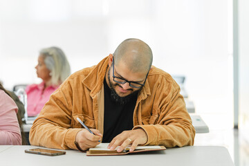 Portrait of a man writing at university