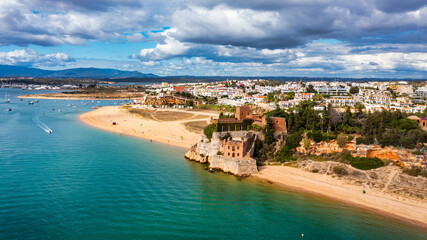 Ferragudo with the Praia Grande (the main beach) and the river Rio Arade, Algarve, Portugal. Beautiful seascape with beach, cave and ocean, Praia Grande beach, Ferragudo, Lagoa, Algarve, Portugal.