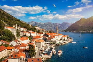 Obraz premium View of the historic town of Perast at famous Bay of Kotor on a beautiful sunny day with blue sky and clouds in summer, Montenegro. Historic city of Perast at Bay of Kotor in summer, Montenegro.