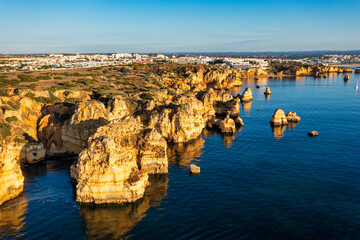 Panoramic view, Ponta da Piedade near Lagos in Algarve, Portugal. Cliff rocks and tourist boat on...