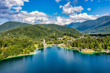 Aerial view of Bohinj lake in Julian Alps. Popular touristic destination in Slovenia. Bohinj Lake, Church of St John the Baptist. Triglav National Park, Julian Alps, Slovenia.