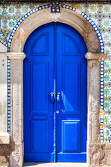 A blue door with a rope hanging from it, Tavira, Algarve, Portugal.