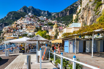 View of Positano with comfortable beach and blue sea on Amalfi Coast in Campania, Italy. Positano village on the Amalfi Coast, Salerno, Campania. Beautiful Positano, Amalfi Coast in Campania. - obrazy, fototapety, plakaty