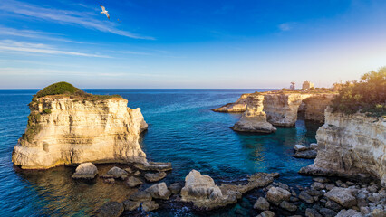 Stunning seascape with cliffs rocky arch and stacks (Faraglioni) at Torre Sant Andrea, Salento...