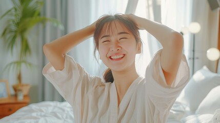 Asian beautiful girl in pajamas wake up in the morning with happiness. Attractive young woman smiling, feel happy and relax then stretching body after getting