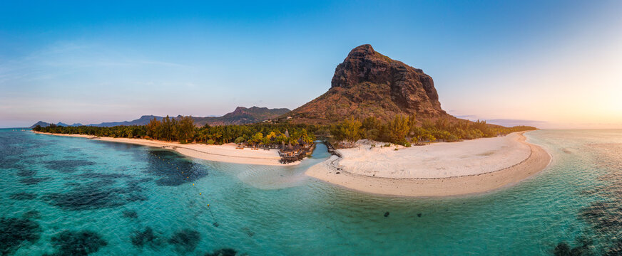 Beach with palm trees and umbrellas on Le morne beach in Mauriutius. Luxury tropical beach and Le Morne mountain in Mauritius. Le Morne beach with palm trees, white sand and luxury resorts, Mauritius