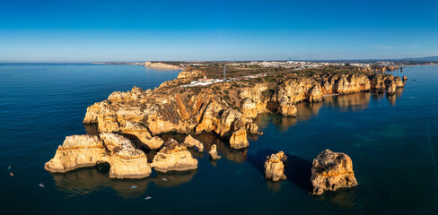 Panoramic view, Ponta da Piedade near Lagos in Algarve, Portugal. Cliff rocks and tourist boat on...