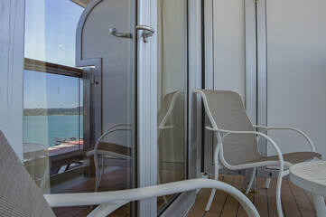 Deck chairs or sun loungers with table on balcony or terrace or patio of luxury cabin stateroom...