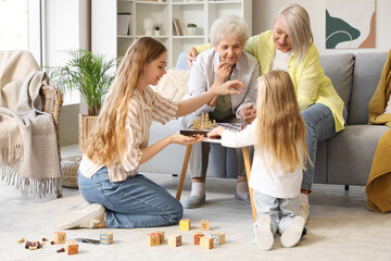 Little girl with her family playing chess at home