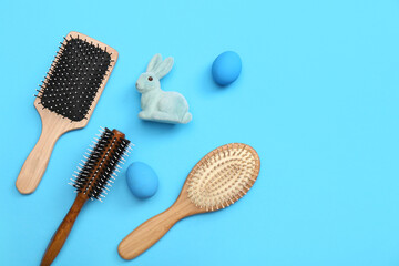 Hair brushes with Easter eggs and bunny on blue background