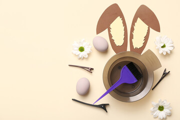 Easter eggs with paper bunny ears, daisies and hairdressing accessories on beige background