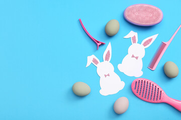 Hairdressing accessories with Easter eggs and paper bunnies on blue background