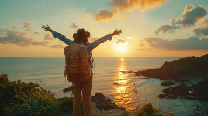 girl standing on a cliff with her arms in the air as the sun sets over the ocean