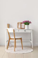Vase with tulips on table in light living room