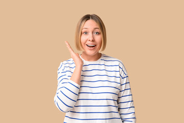 Surprised adult woman on beige background