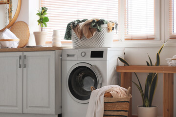 Full laundry basket on washing machine in bathroom interior