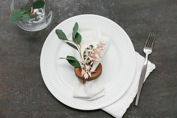 Table setting with beautiful flowers and leaves on black background