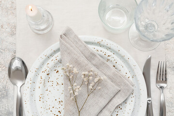 Beautiful table setting with gypsophila flowers on grey background