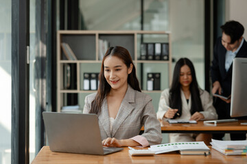 an employee is working in modern office and another coworkers are in the same room, working atmosphere in the office, businesspeople, work happily in the company