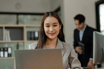 an employee is working in modern office and another coworkers are in the same room, working atmosphere in the office, businesspeople, work happily in the company