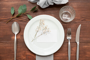Beautiful table setting with gypsophila flowers and leaves on wooden background