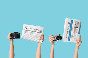 Female hands with newspapers and photo cameras on color background