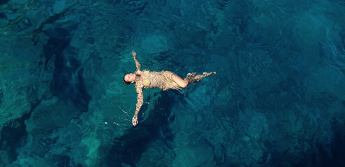 A woman floating and relaxing in the sea  on a sunny day