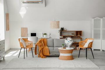 Interior of stylish living room with modern electric fan on coffee table