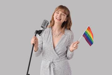 Female singer with LGBT flag and microphone on light background