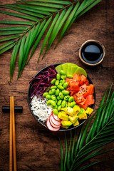 Poke bowl for balanced diet with salmon, avocado, radish, cabbage, beans, sesame and rice, wooden...