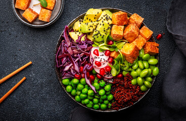Vegan Buddha Bowl for balanced diet with roasted tofu, red quinoa, vegetables, legumes, seeds and...