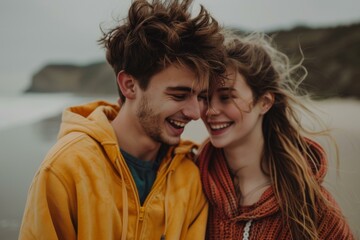 A young couple is laughing and smiling at each other on a beach. AI.