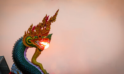 the naga statue and the sun at sunset with dramatic tone